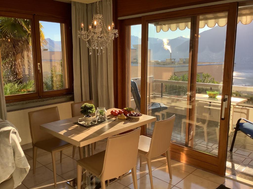 een eetkamer met een tafel en stoelen en een raam bij Condominio Andromeda Seeblick in Locarno