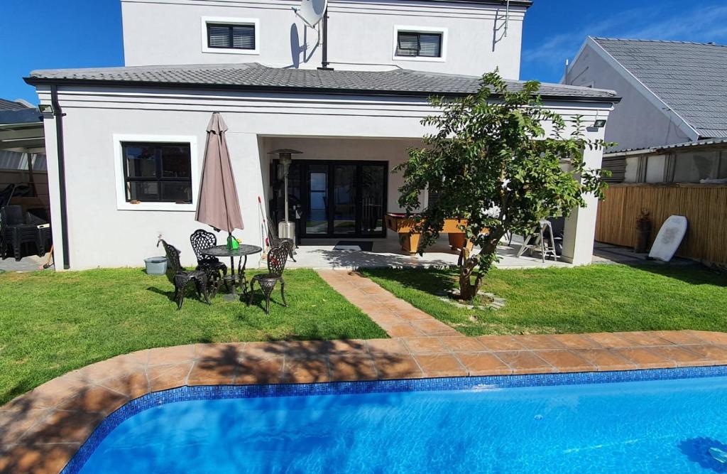a house with a swimming pool in front of a house at Villa Parisienne Modern Guest house in Cape Town