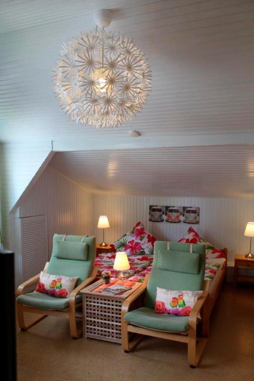 a room with two chairs and a bed and a chandelier at Ferienwohnung Carstensen Nr2 in Fehmarn