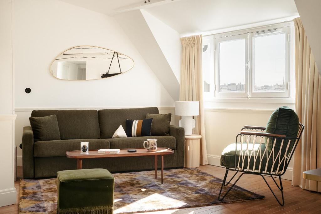 sala de estar con sofá y mesa en My Maison In Paris - Louvre, en París