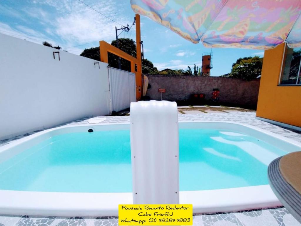 una piscina con bañera en un patio en Recanto Redentor, en Cabo Frío