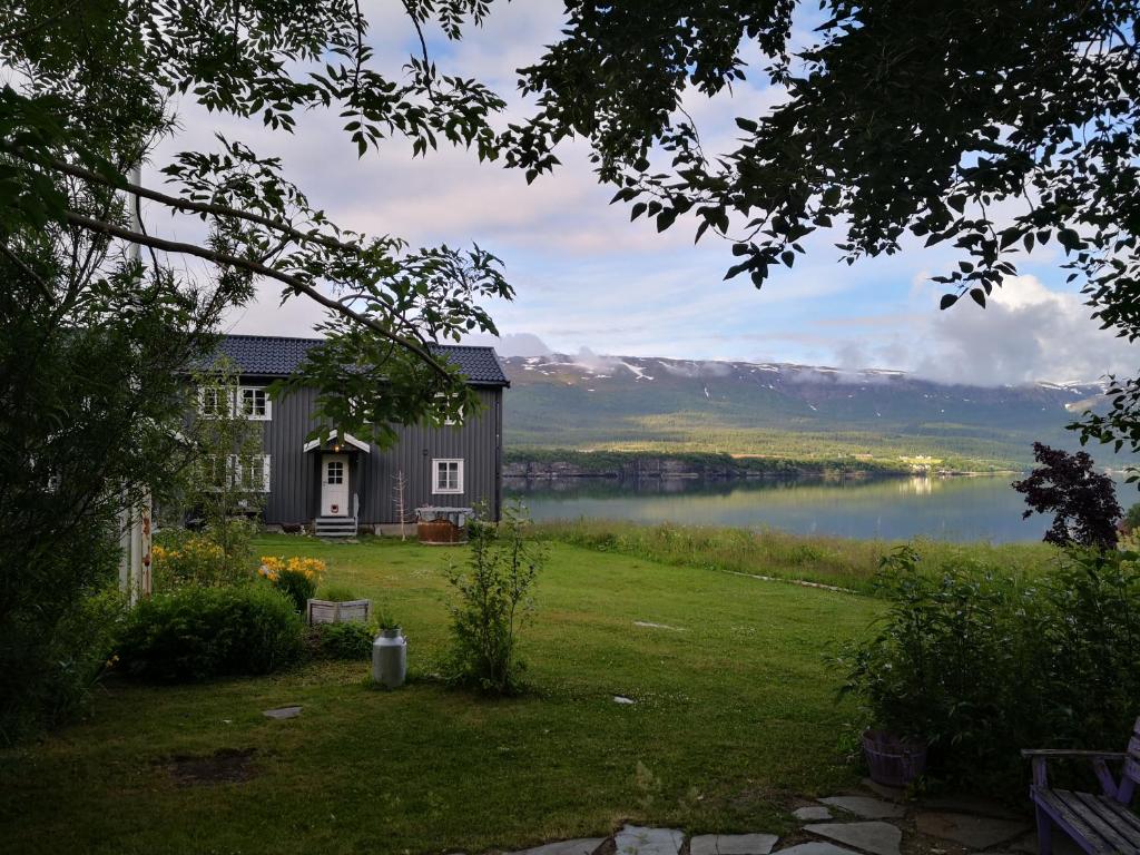 a house with a view of a lake and mountains at Aline's Stue, B&B Utskarpen in Fuglstad