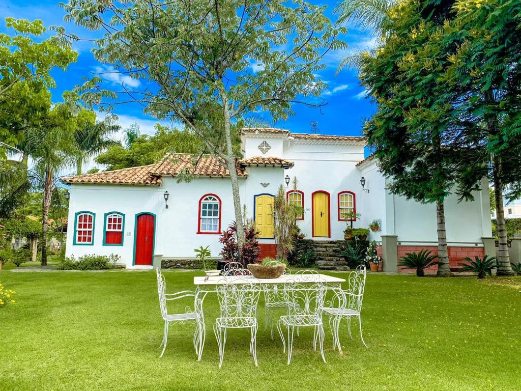 uma mesa e cadeiras em frente a uma casa em Pousada do Barão em Santa Rita do Sapucaí