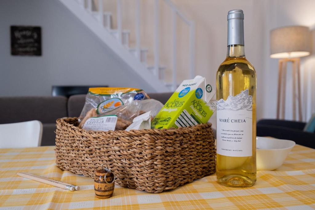 a basket of food and a bottle of wine on a table at Casa Vista da Marquesa in Nordeste