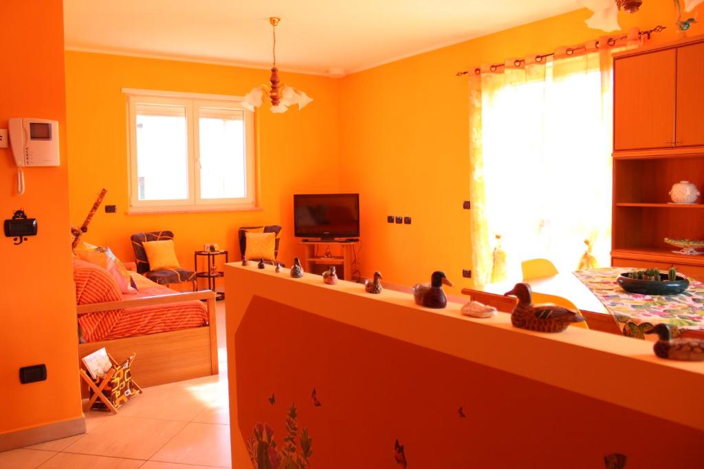 アローナにあるIl Mondo di Dedoのオレンジ色の壁のキッチン、リビングルーム