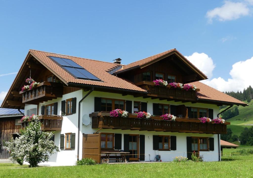 ein Haus mit Sonnenkollektoren auf dem Dach in der Unterkunft Hemerhof in Oberstdorf