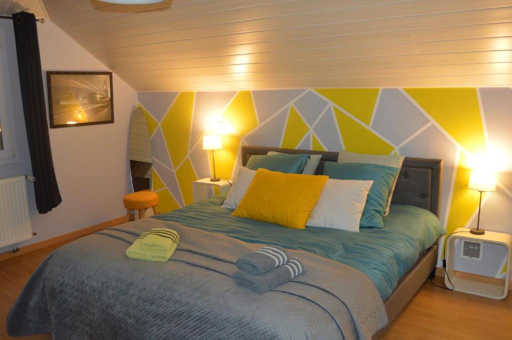 1 dormitorio con 1 cama de color amarillo y azul en chambre d hôtes à la campagne, en Tilleux