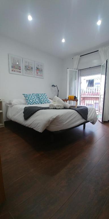 a large bed in a bedroom with a large window at Apartamento Madreselva 36 in Granada