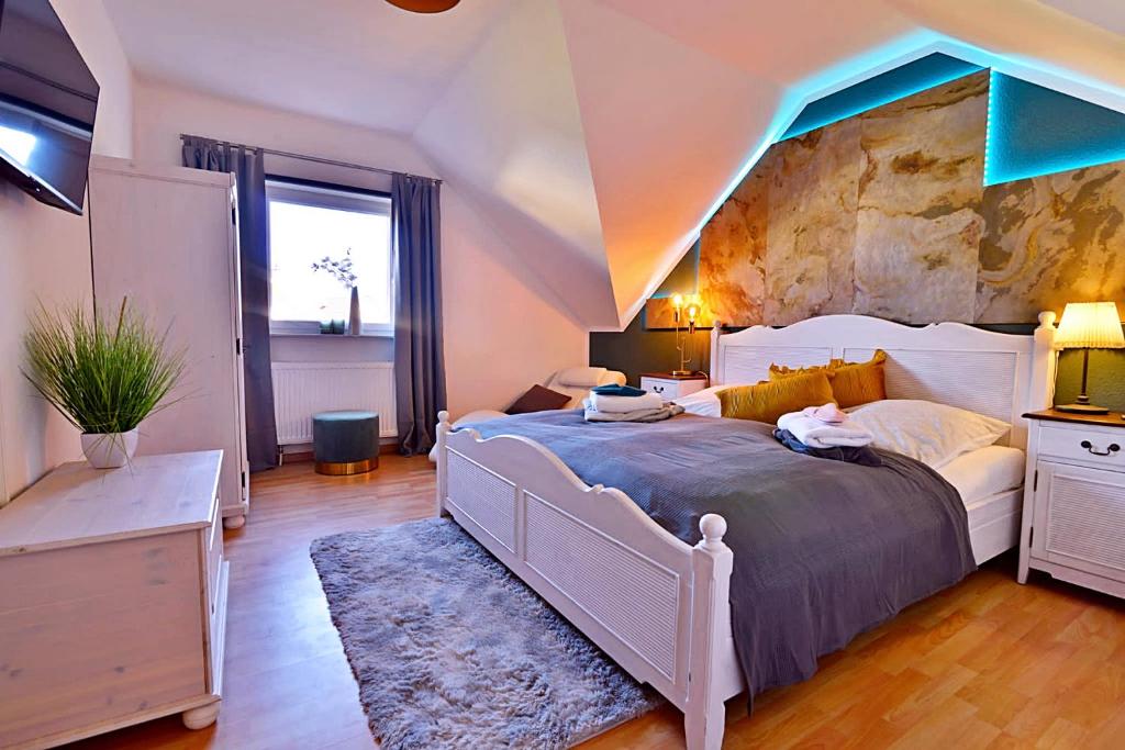 a bedroom with a large bed with a stone wall at Ferienwohnung Am Wäldchen in Erfurt