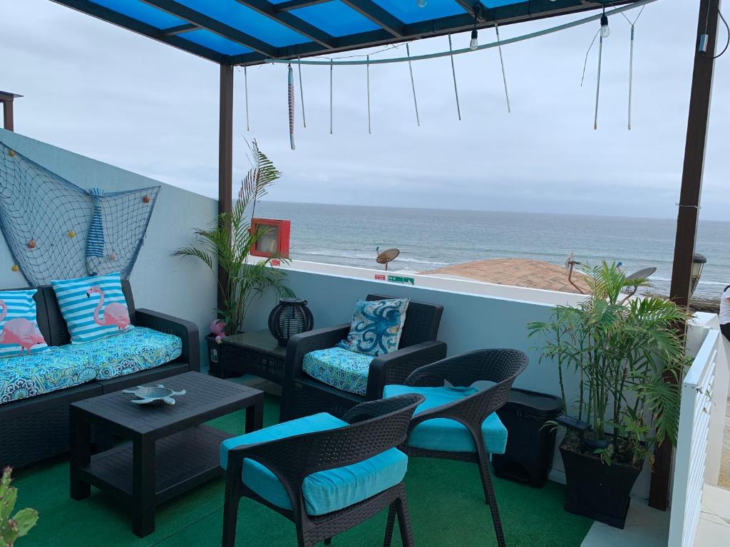 balcón con sillas, sofá y vistas al océano en Departamento Frente al Mar -MANTA, en Manta