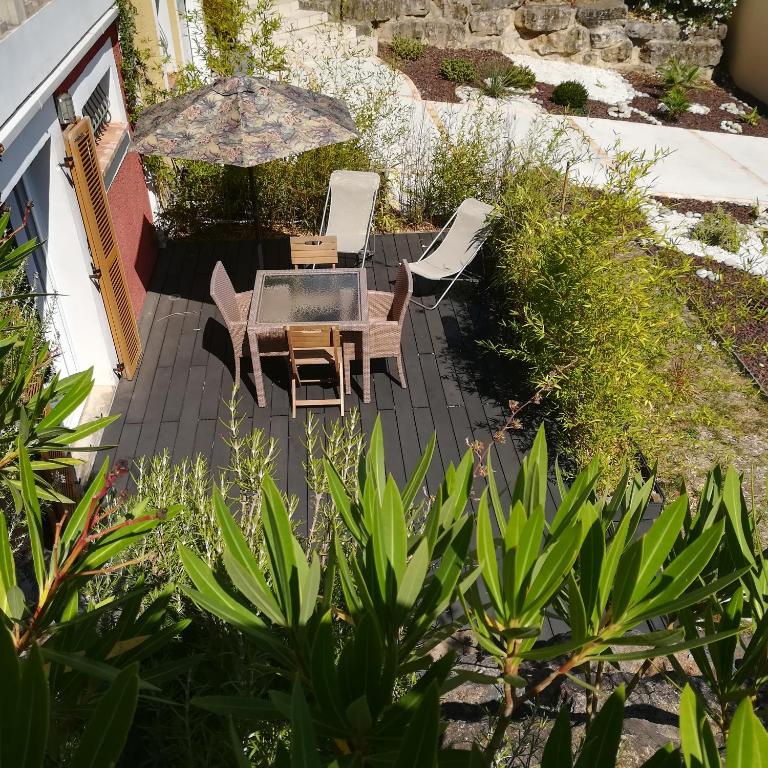 un patio avec une table, des chaises et un parasol dans l'établissement grand studio des rivages cathares, à Carcassonne