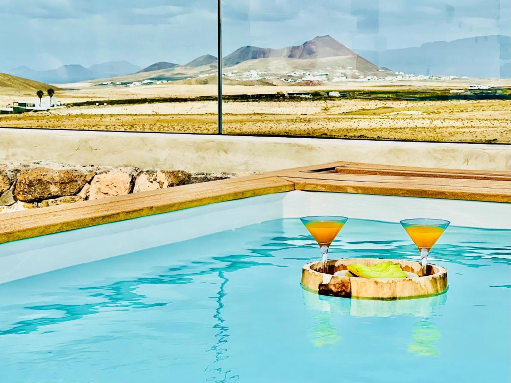 due bicchieri di vino in piscina di Canaryislandshost l The Sky Suites a Tinajo