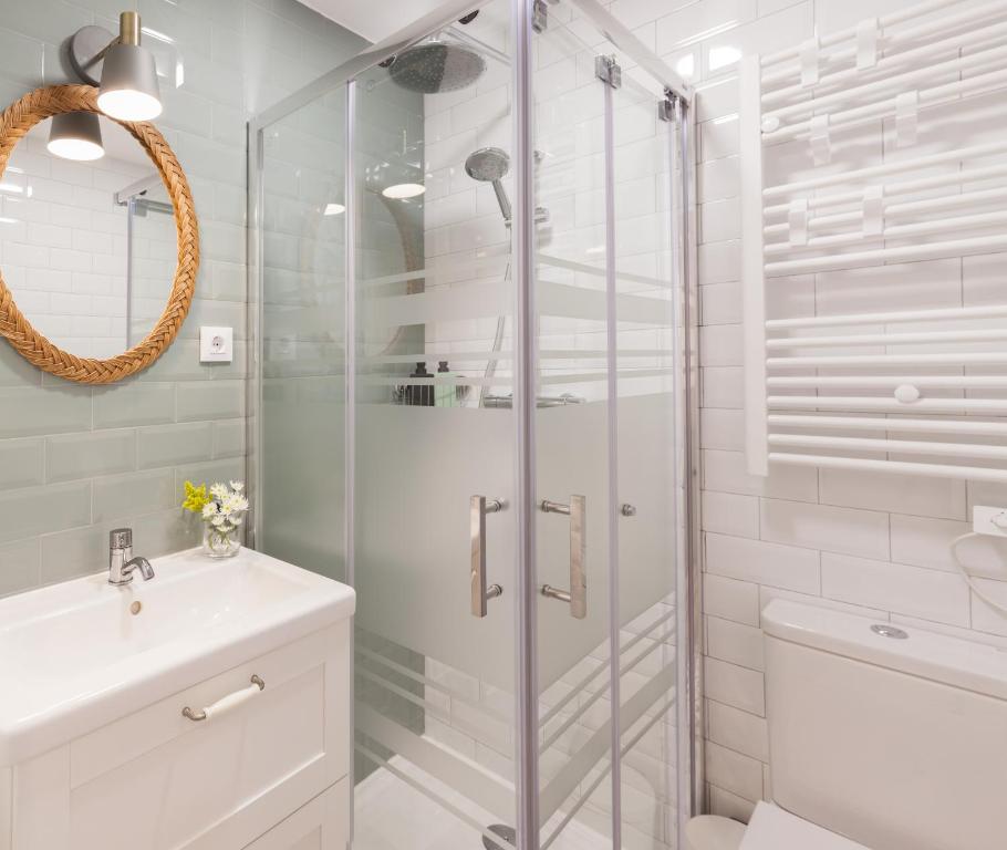 a white bathroom with a shower and a sink at Dolphin Rentals Hortaleza in Madrid