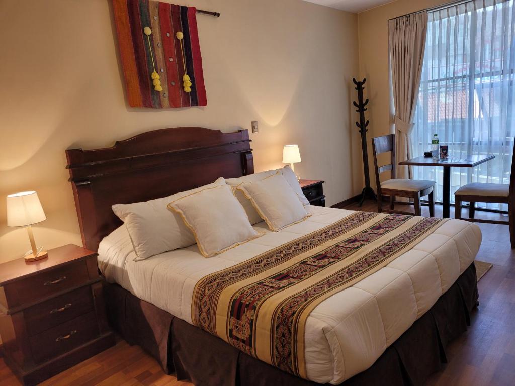 a bedroom with a large bed with a table and chairs at Hotel Monte Carlo in La Paz