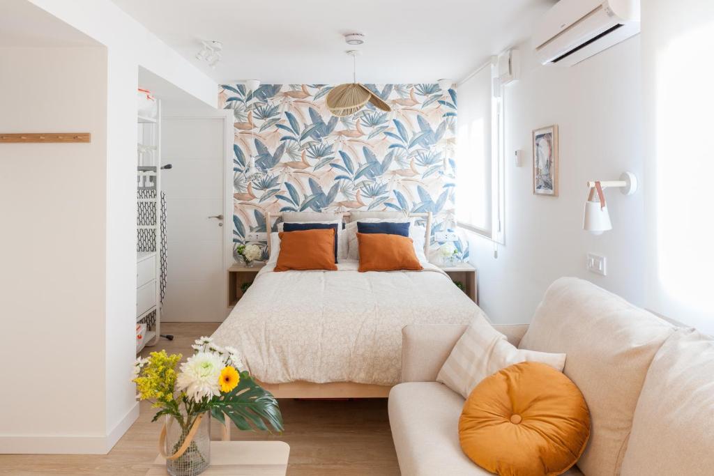 um quarto com uma cama e um sofá em Dolphin Rentals Feria de Madrid em Madrid