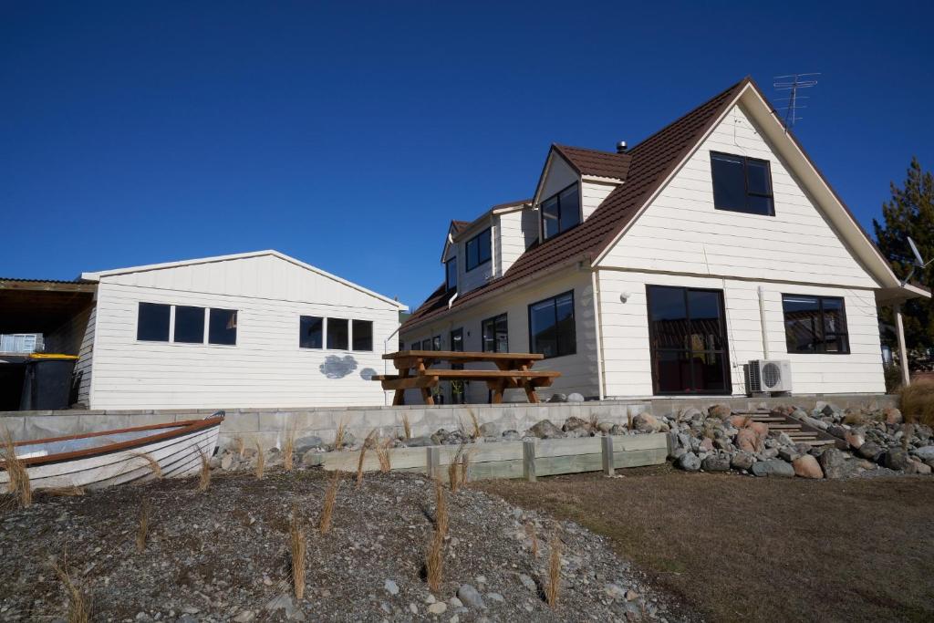 a white house with a fence in front of it at Bedrock - Lake Tekapo in Lake Tekapo