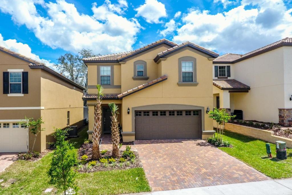 une grande maison avec un garage dans l'établissement Luxury 7BR 6BA Home Private Pool and BBQ only13min to Disney 4788 sqft, à Kissimmee