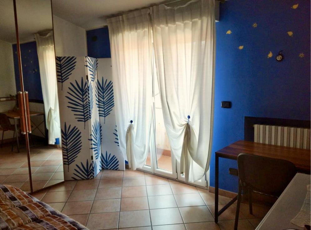ein Schlafzimmer mit einer Tür mit Vorhängen und einem Tisch in der Unterkunft Casa Ada in Bollate