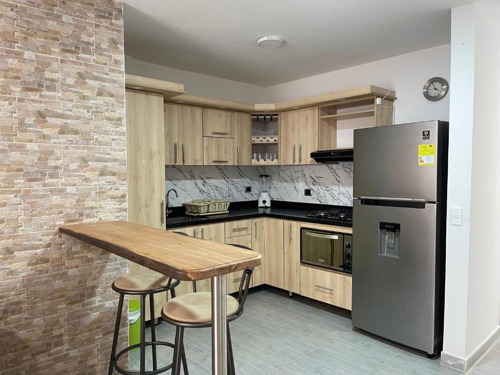 a kitchen with a refrigerator and a wooden table at apartamento Hope Guatape in Guatapé