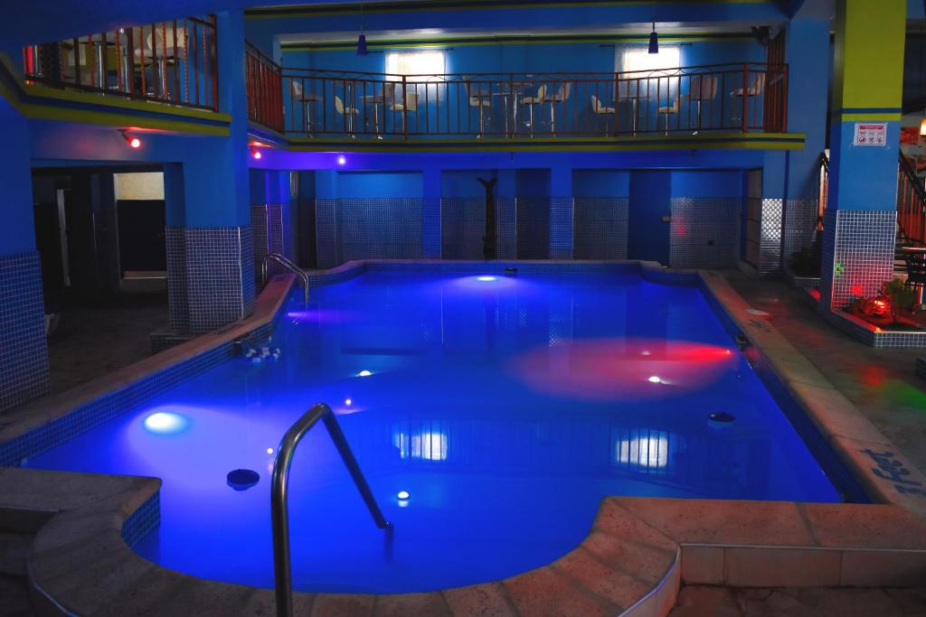 una gran piscina con iluminación azul en un edificio en La Pepiniere Hotel, en Pétionville