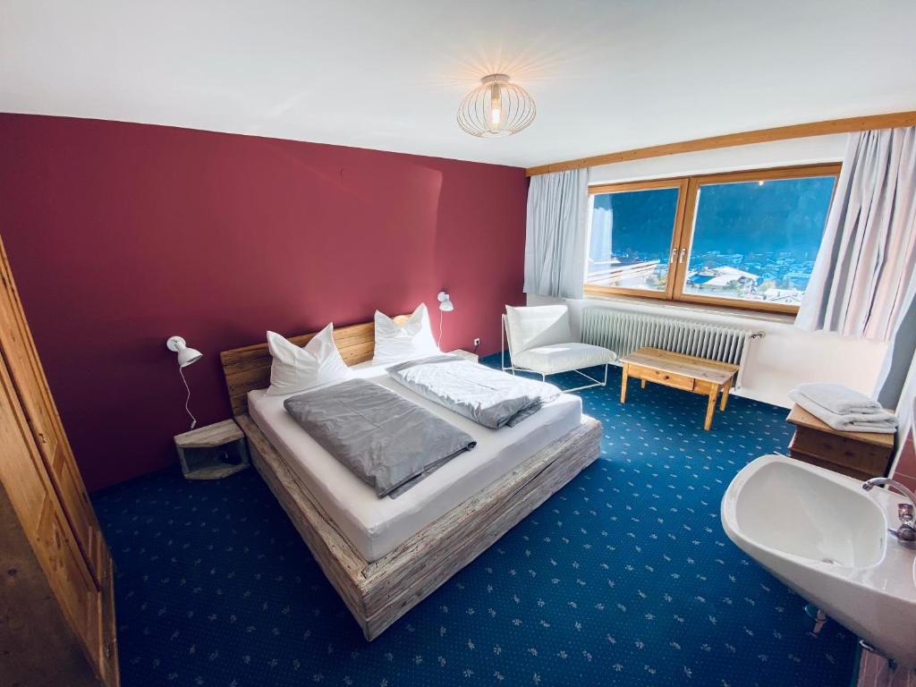 Schlafzimmer mit einem Bett, einem Waschbecken und einer Badewanne in der Unterkunft Königin Serles - großzügig, gemütlich & nachhaltig in Fulpmes