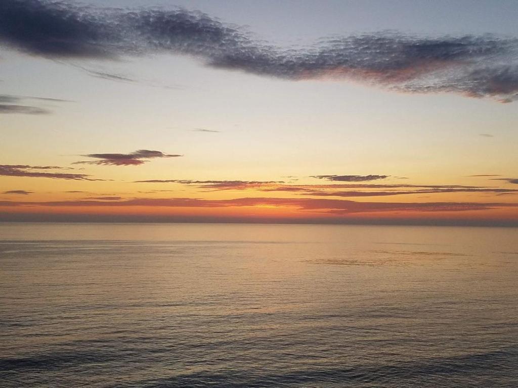 a sunset over the ocean with the sky at Beachfront Calafia Condos in Rosarito