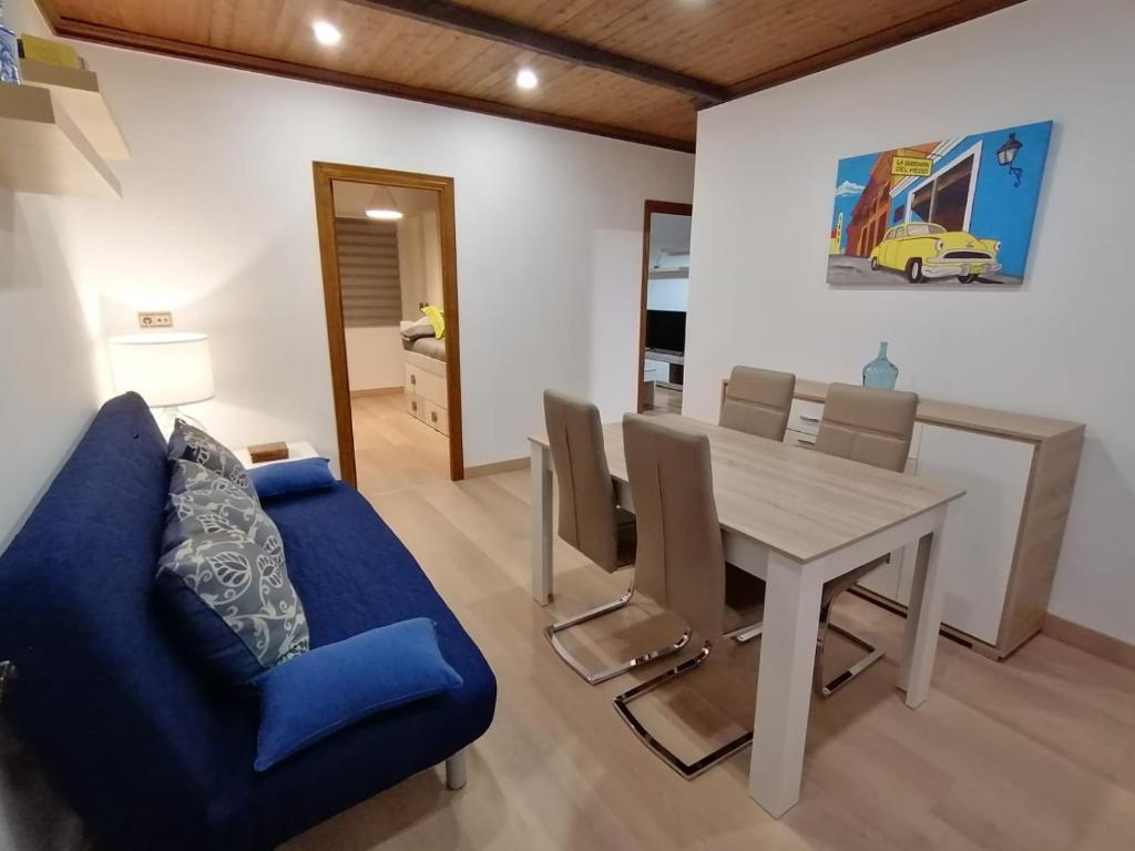 une salle à manger avec un canapé bleu et une table dans l'établissement Spacious Apartment, à Armilla