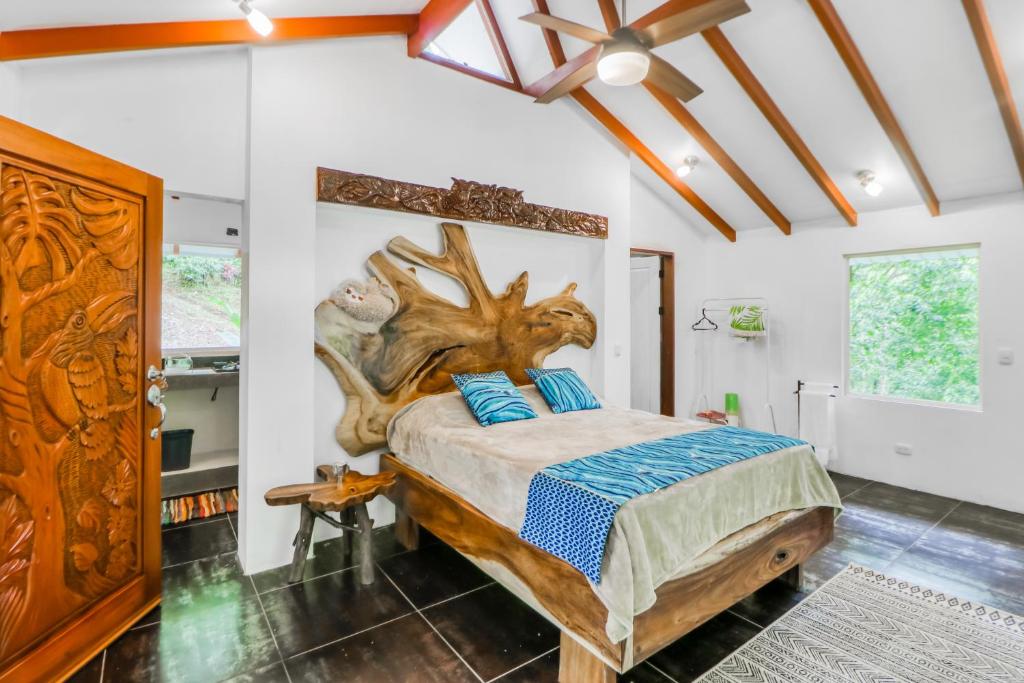 - une chambre avec un lit et une tête de lit en bois dans l'établissement Lost Pools Bungalow, à Uvita