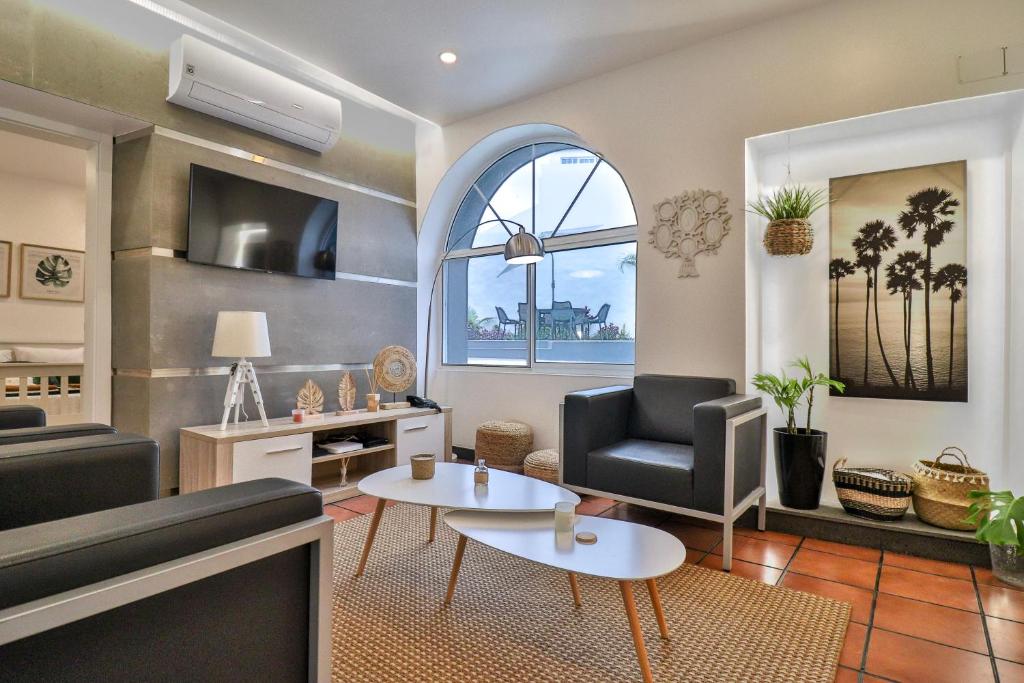 een woonkamer met een bank en een tafel bij Janela Mar Garden in Lagoa