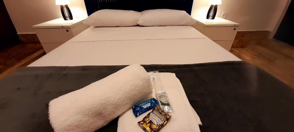um quarto com 2 camas com lençóis brancos e toalhas em LÍAH Hostel & Suites em São Paulo
