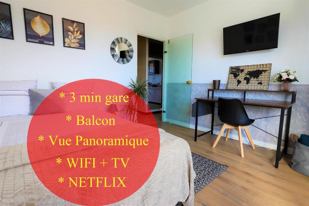 una camera con un letto e una scrivania con un cartello rosso di Appartement secteur gare avec balcon et vue panoramique a Chambéry