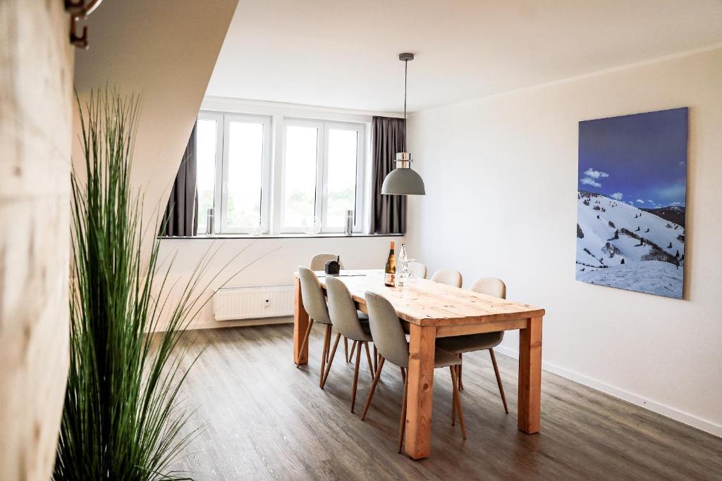 a dining room with a wooden table and chairs at Smart Resorts Haus Azur Ferienwohnung 811 in Winterberg
