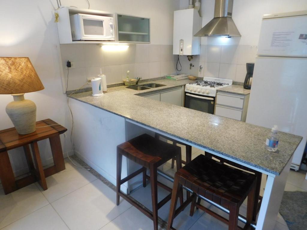 a kitchen with a counter and some stools in it at Dep Catedral in San Carlos de Bariloche