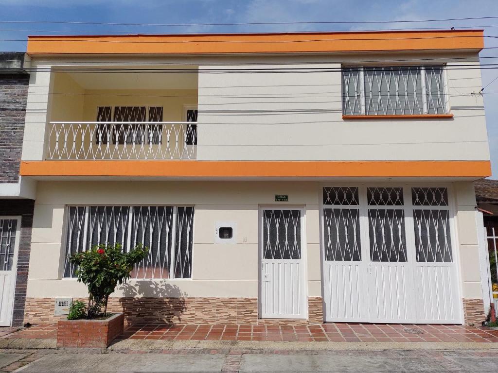 Casa con puertas blancas y balcón. en Agradable casa vacacional cerca al centro de Anapoima en Anapoima