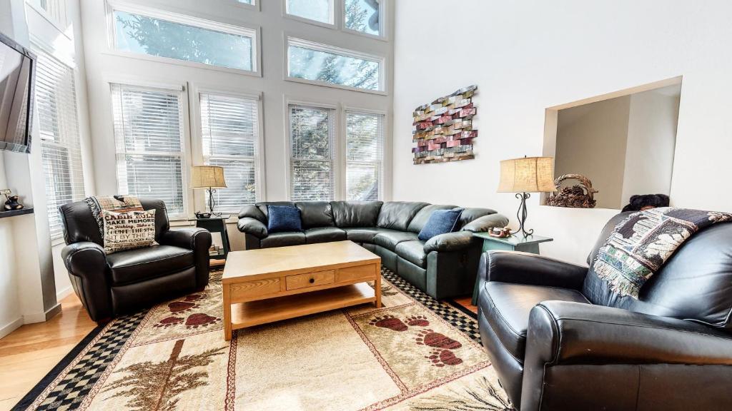 a living room with leather couches and a table at Snowcreek #840 condo in Mammoth Lakes
