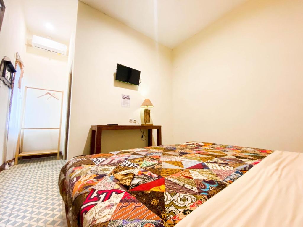 Postel nebo postele na pokoji v ubytování Hinggil Homestay Syariah Malioboro Yogya Mitra RedDoorz