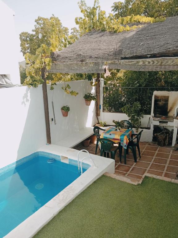 a patio with a table and a swimming pool at La Casita Verde Valle in La Fuente Grande