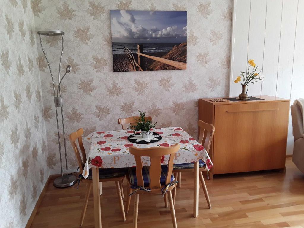une salle à manger avec une table, des chaises, une table et une lampe dans l'établissement Ferienwohnung Panorama, à Bad Peterstal-Griesbach