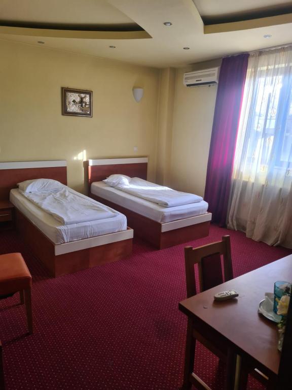 a hotel room with two beds and a table at Bistro 29 in Ploieşti