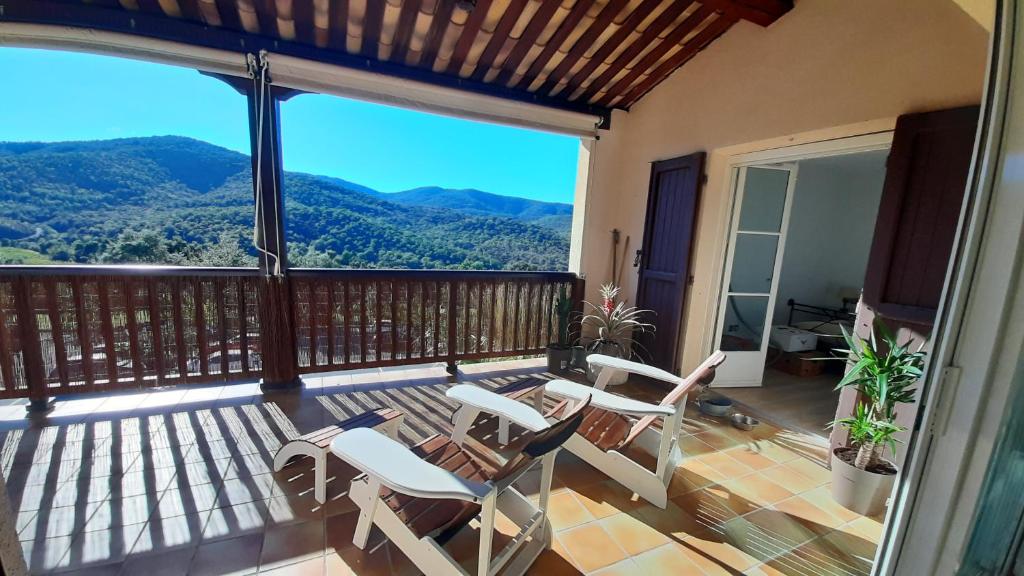 uma varanda com cadeiras e vista para as montanhas em Appartement domaine du Golf de Roquebrune Resort - Résidence Le Saint Andrews em Roquebrune-sur-Argens