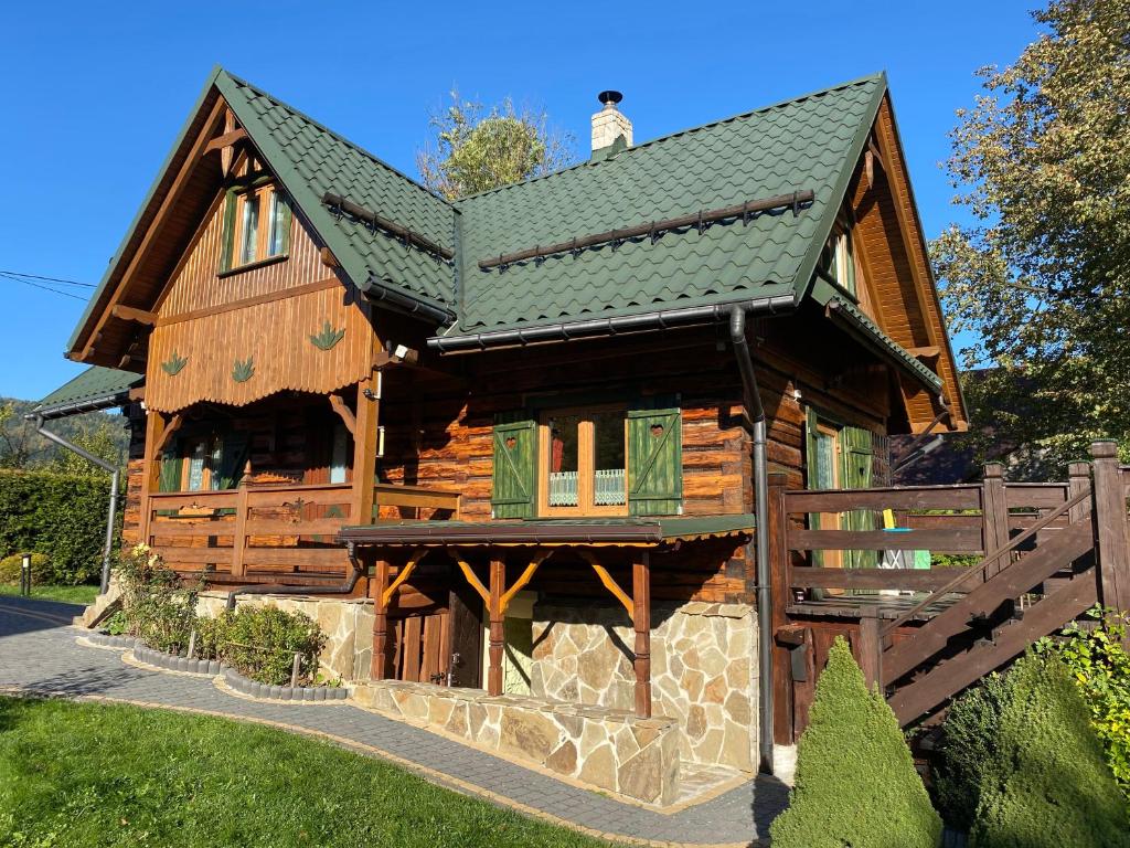 a large wooden house with a green roof at Czym Chata Bogata in Korbielów