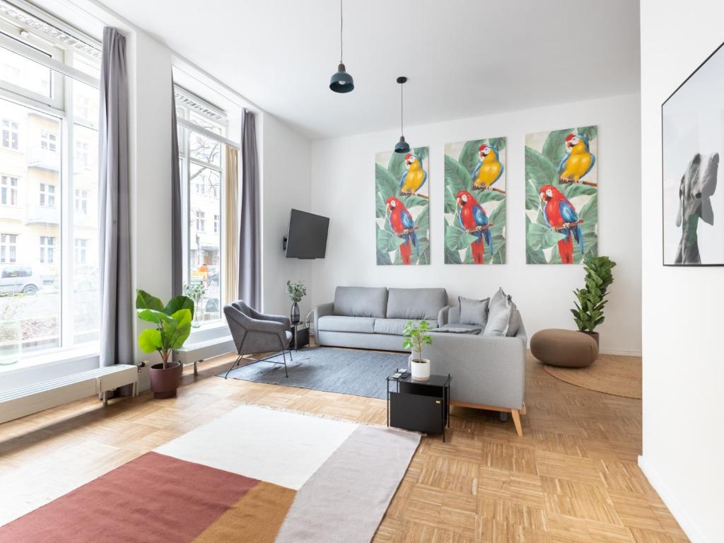 a living room with a couch and paintings on the wall at limehome Berlin Florastraße in Berlin