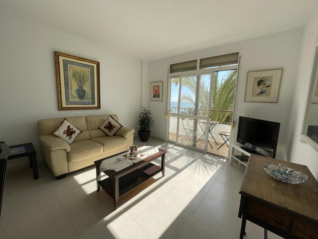a living room with a couch and a table at Apartamento frente a la playa Piso 3 in Estepona