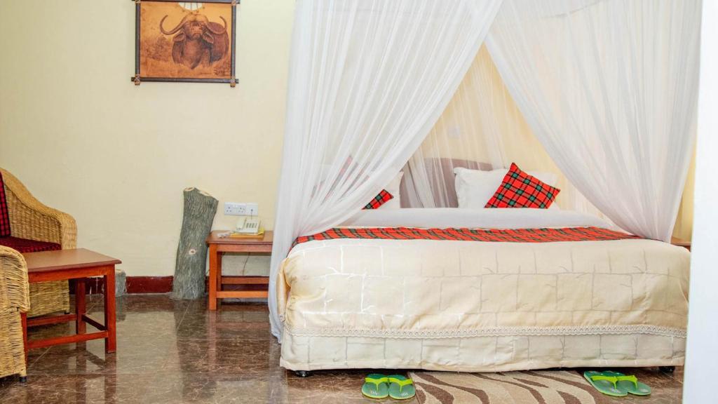 una camera con letto a baldacchino di Karibu Heritage House ad Arusha