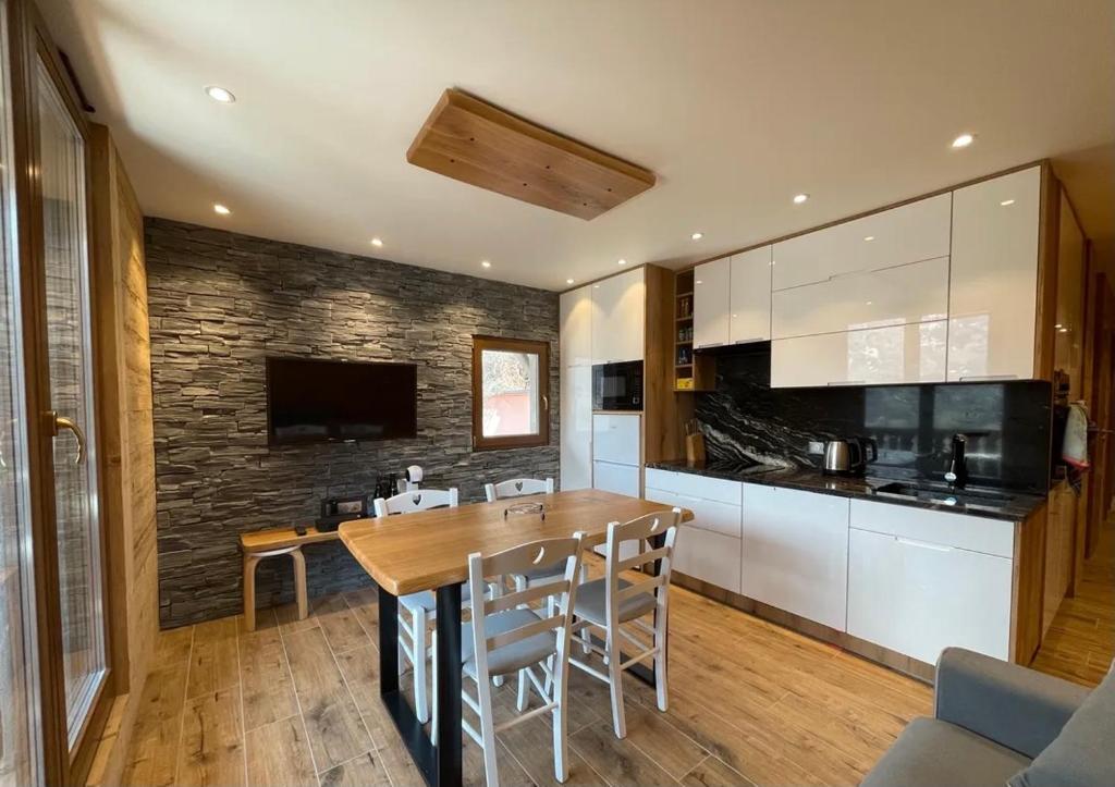 a kitchen with a wooden table and a dining room at Les Balcons de Valloire in Valloire