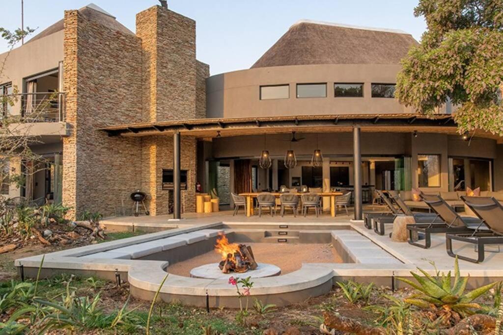 una casa con una hoguera delante de ella en Luxury Villa looking onto Kruger National Park, en Belfast