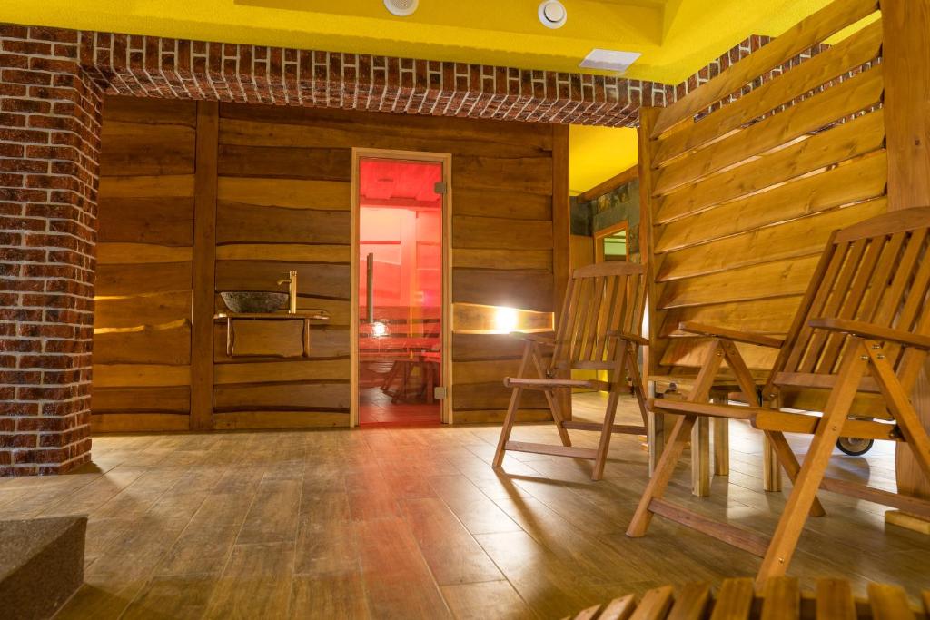 a room with wooden walls and wooden chairs and a table at Penzion U Jirsáka in Vikýřovice