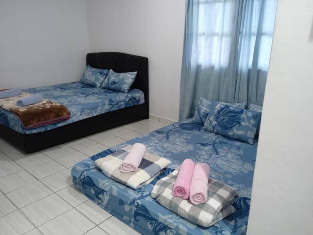 een slaapkamer met 2 bedden en handdoeken bij Dongorit Cabin House no.2 in Kampong Kundassan