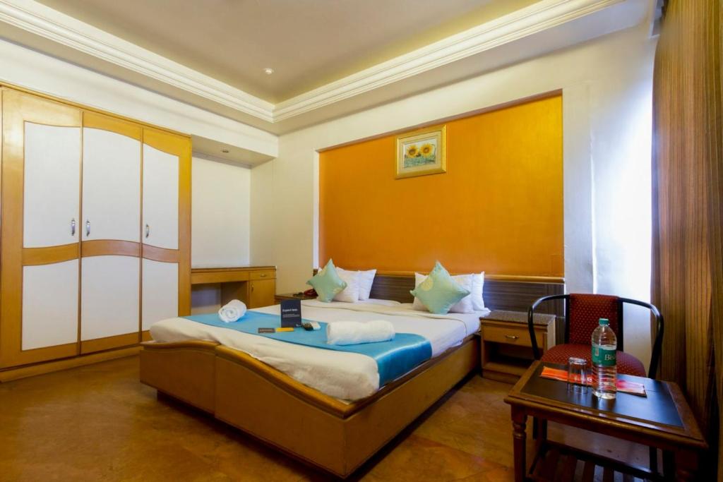 Habitación de hotel con cama y mesa en Celebrations Inn Pune, en Pune