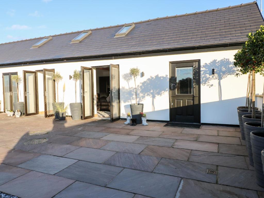 a white building with a patio with chairs on it at Bear Cottage in Belper